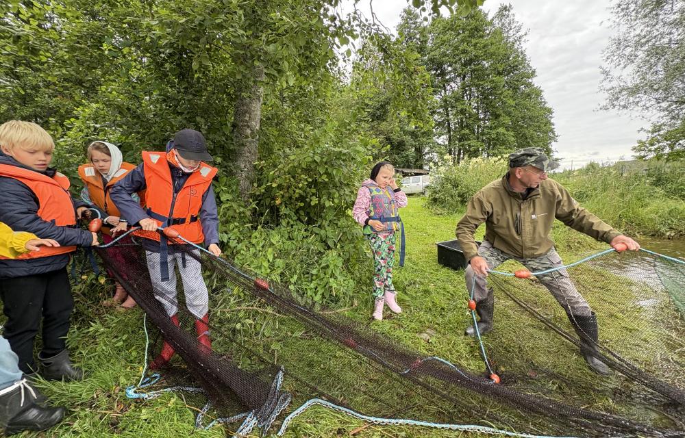 inimesed võrke veest välja tõmbamas